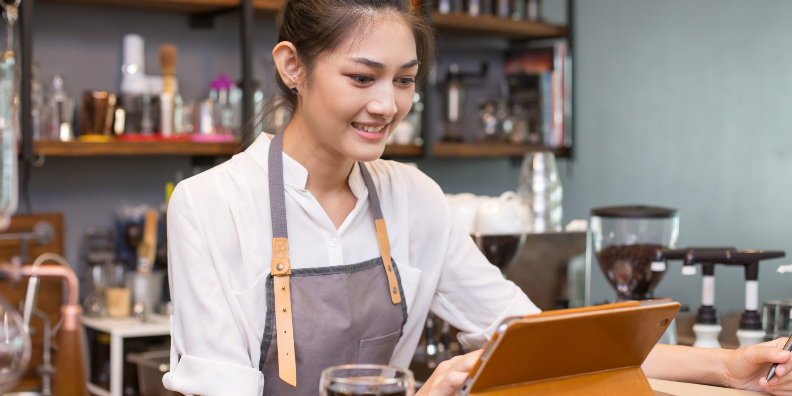 Asian barista woman using tablet for promote shop. Woman using t